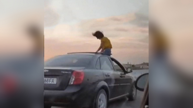 Видео: Девушка, высунувшаяся из люка автомобиля, оштрафована